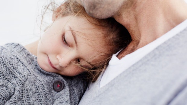 Daughter with head resting on fathers chest