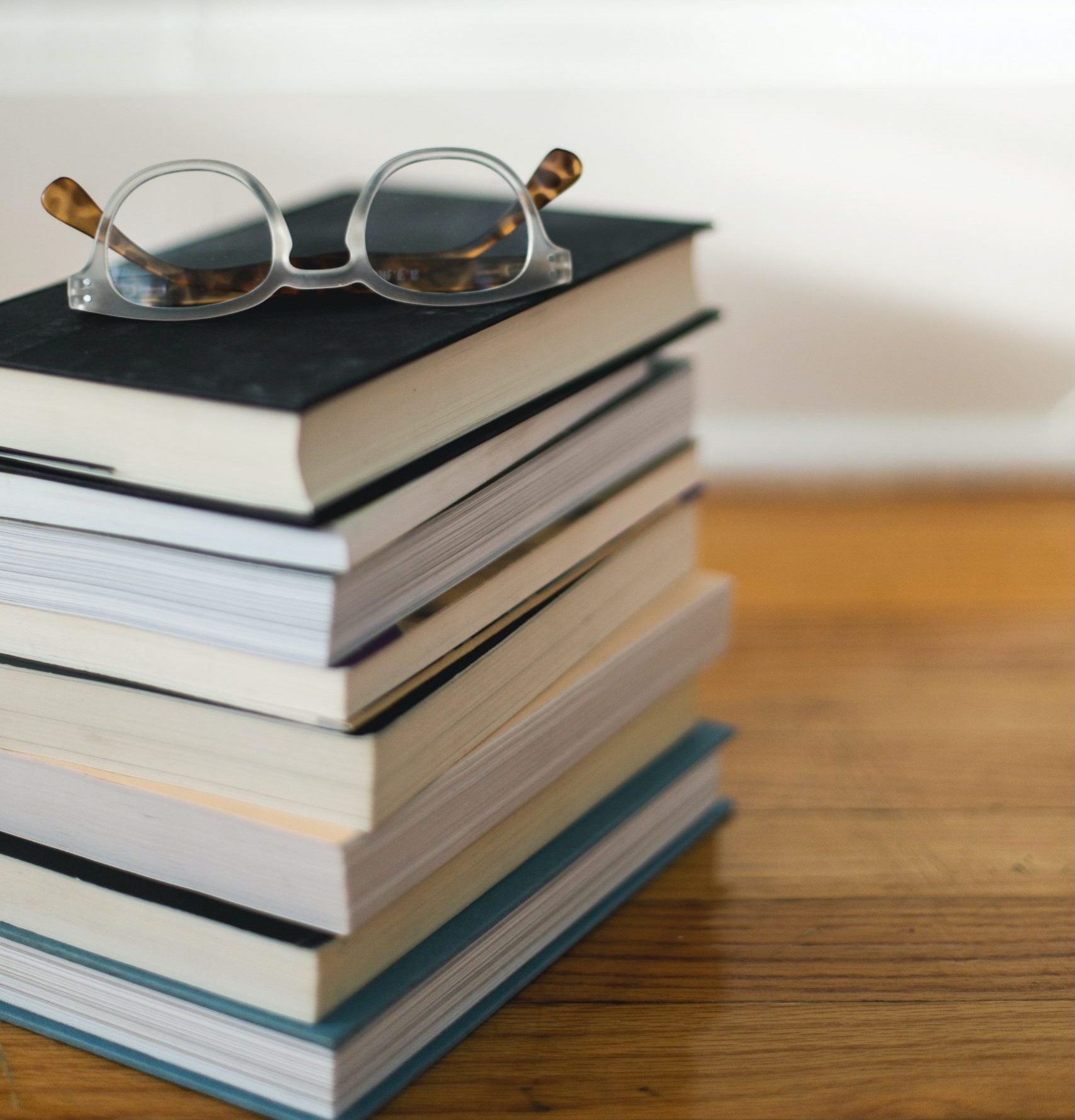 Pile of Books with glasses on top